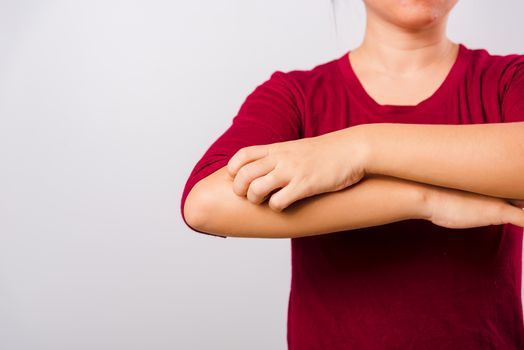 Asian beautiful woman itching her scratching her itchy arm on white background with copy space, Medical and Healthcare concept