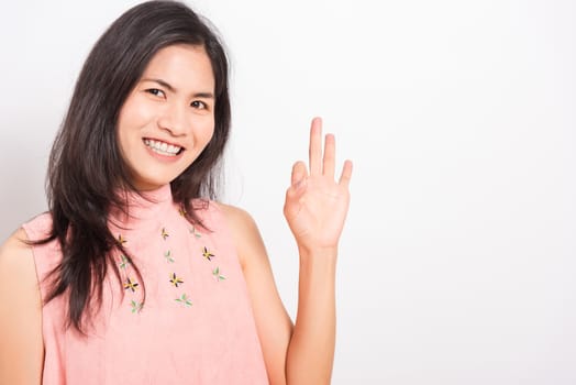 Portrait Asian beautiful young woman standing, She made finger OK symbol sign to agree and looking at camera, shoot photo in studio on white background, There was copy space