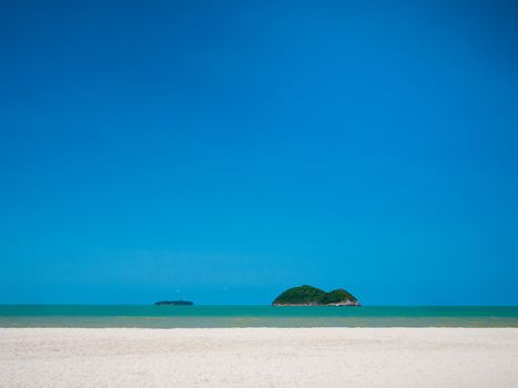 White sand beach with clear blue sky without cloud over sea and two island .