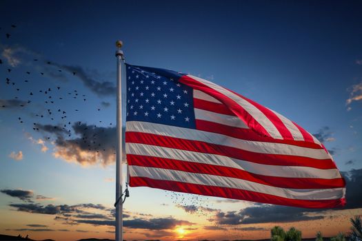 An American flag blowing in the wind under clear blue skies