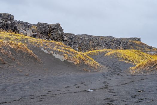 Bridge between the continents in Iceland black sand forming dunes