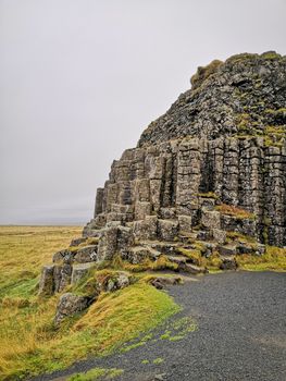 Dverghamrar dwarf hammer natural basalt columns covered in grass and moss in southern Iceland