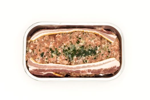 Meatloaf ready to bake in its aluminum tray top view isolated on white background