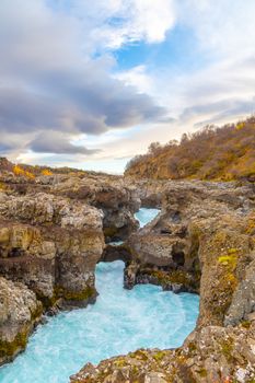 Hraunfossar series of waterfalls barnafoss turquoise water streaming down gorge in Icelands highlands