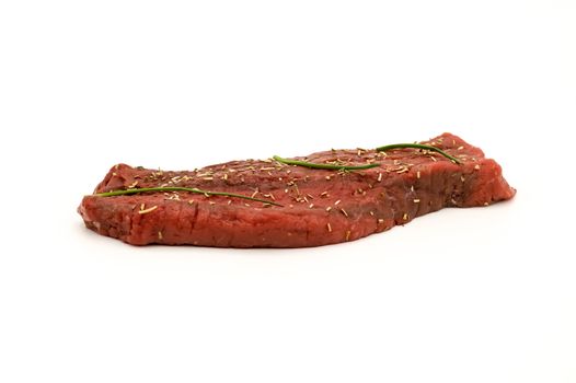 Beef steak with herbs of provence and chives on white background