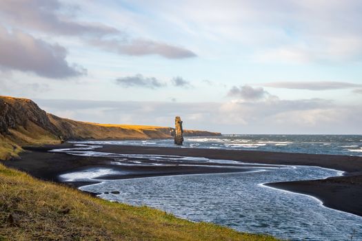 Hvitserkur rock formation in Iceland on black beach in front of high cliffs