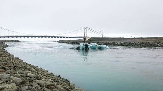 Joekulsarlon Glacier Lagoon deep blue icebergs in front of old suspension bridge