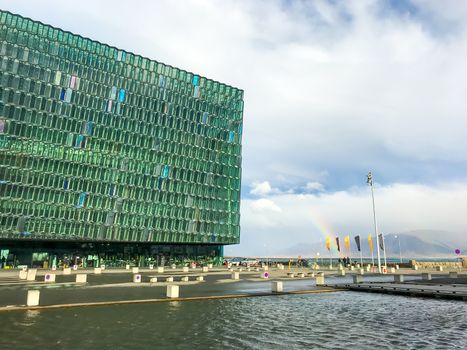 Reykjavik in Iceland Harpa concert hall next to rainbow during rainy day