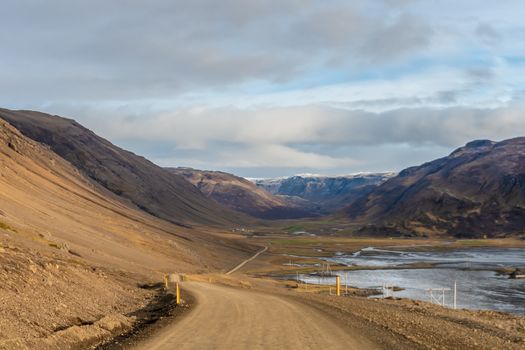 Road trip in Iceland dirt road in west iceland winding down into fjord during sunny weather