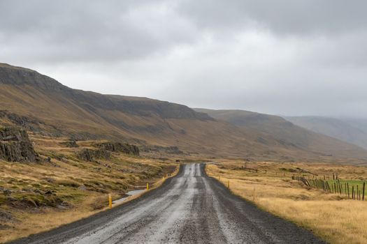 Road trip in Iceland gravel road along icelandic coast during rainy grey weather