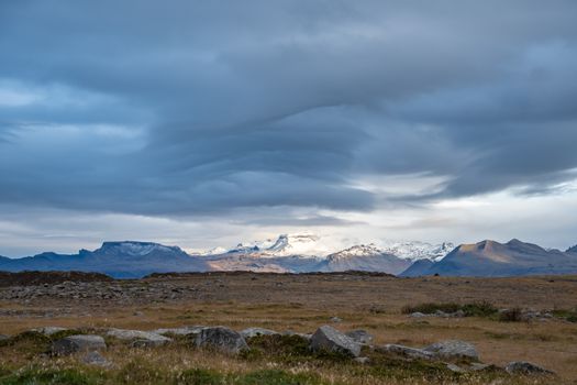 Snaefellsness national park in Iceland Snaefellsjoekull glacier in sunlight spot next to wave form in sky
