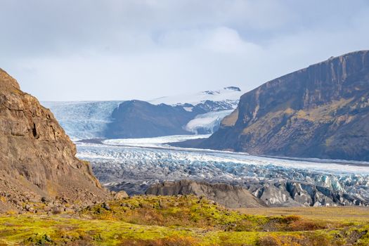 Vatnajoekull glacier in Iceland eternal ice deep blue flowing down the mountain slopes