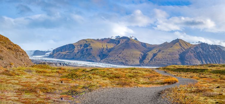 Vatnajoekull glacier in Iceland hiking path leading through autumn colored landscape towards glacier lakes