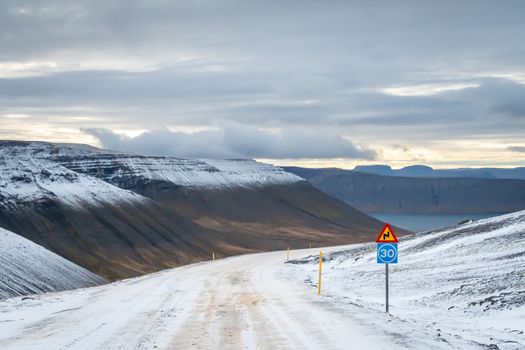 West fjords of Iceland mountain pass icy and sharp curve ahead