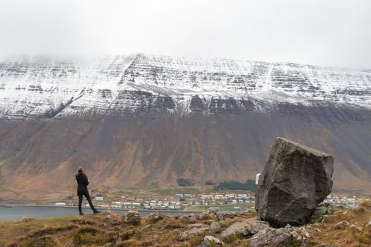 West fjords of Iceland Naustahvilft The Troll Seat person looking towards Isafjoerdur
