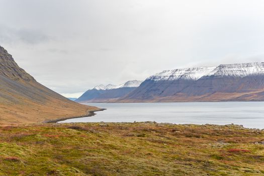 Westfjords of Iceland view into fjord close to Dynjandi waterfall during autumn mountain tops covered in white
