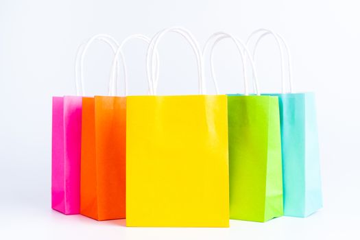 Colorful shopping bags standing in a row isolated on white background