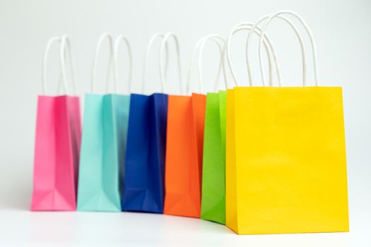 Colorful shopping bags standing in a row isolated on white background