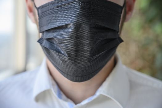 A man wearing a black respiratory mask on his face.
