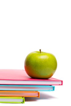 Green apple on notebooks on white background