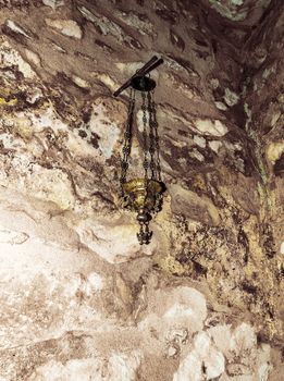 Close up of a hanging brass and class candle holder hanging in Orthodox Church in Penteli, Greece.
