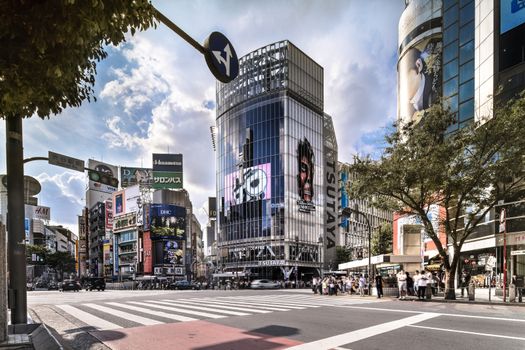 Wide view of the Shibuya Crossing Intersection in front of Shibuya Station on a bright summer day.