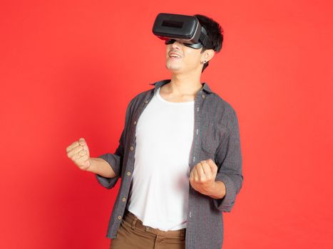 Young Man Wearing VR Headset and exploring another world isolated on red background