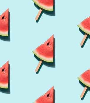 watermelon popsicle seamless pattern. Water melon slice on wooden popsicle stick over blue background. Top view or flat lay. Isometric view