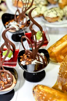 Tray full of cupcakes and slices of cake inside a buffet