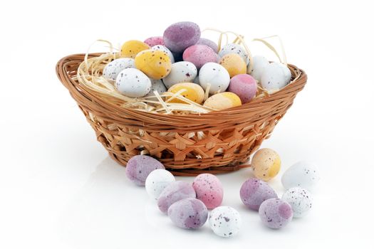 Easter candy in a basket isolated on white background