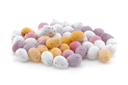 A selection of Yellow pink purple and white Easter candy eggs isolated on a white background