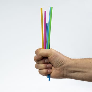 some colored plastic straws in hand