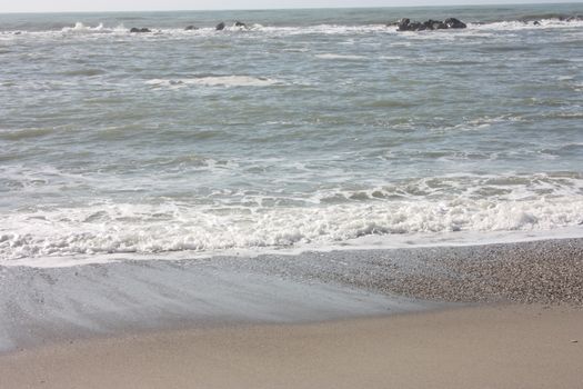 A winter beach with rough seas with cold and dull colors in the Versilian Riviera in italy