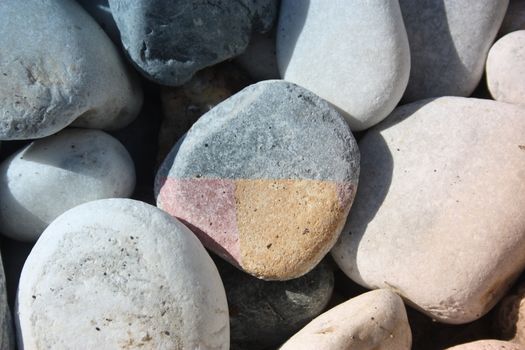 many round colored stones all equal to each other and in the middle a strange colored stone differently in pieces in tuscany