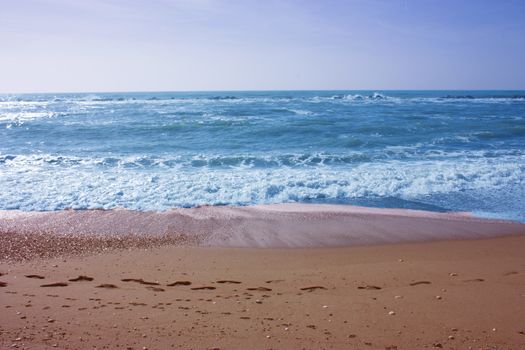 A winter beach with rough seas with cold and dull colors in the Versilian Riviera in italy