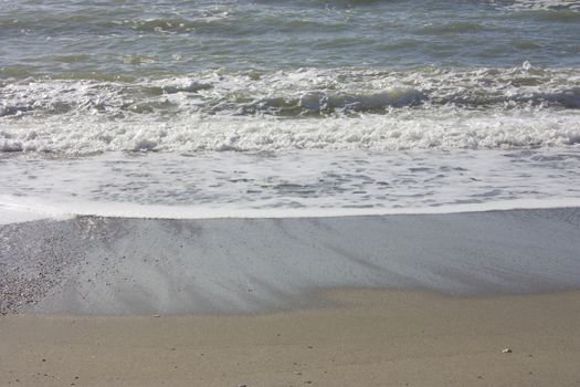 A winter beach with rough seas with cold and dull colors in the Versilian Riviera in italy