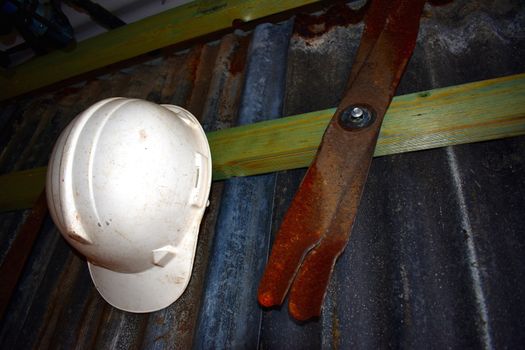 A helmet and tools in a tin shed