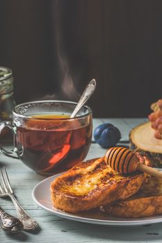 Healthy breakfast concept. French toasts with honey, fruits and tea over white wooden background