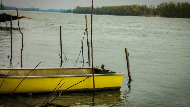Yellow boat moored on the river in Italy
