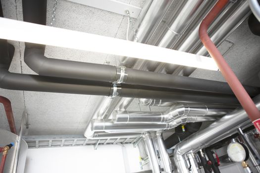 chrome pipes in heating and AC rooms in buildings of factories and hospital shot from below