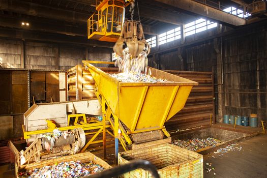 garbage pile getting sorted for recycling of materials. Metal being poured into container