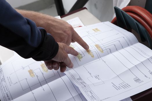 workmen and engineer working an planing on the job showing hands. point towards work