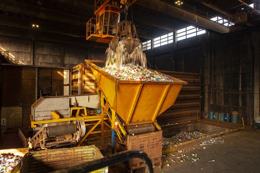 garbage pile getting sorted for recycling of materials. Metal being poured into container