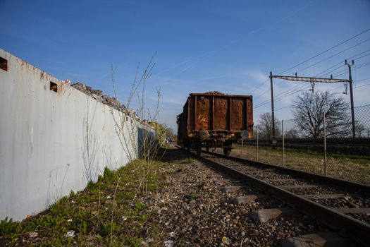 rusty railroad car waiting at recycle station with blue sky