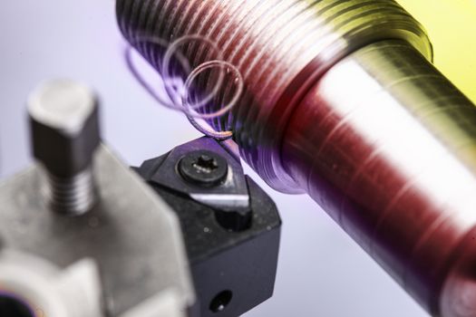 close up of metal cutting on lathe with colored metal