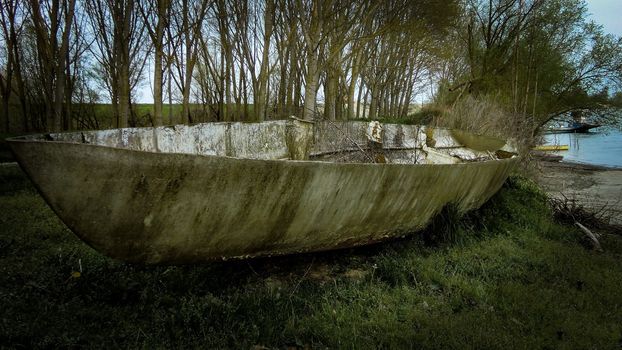 Abandoned boat on the river bank in Italy