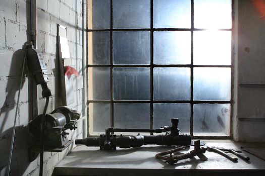old work space with dirty dusty windows and tools. with lights coming from window
