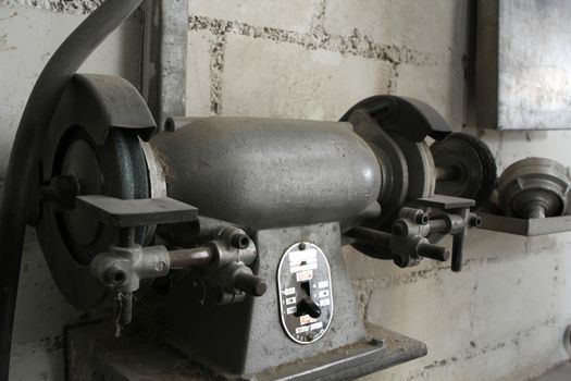 Old grinding machine in an old mechanic shop. with dirty wall