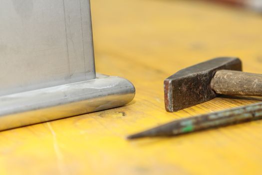 hammer and chisel tools for plumbers with yellow background
