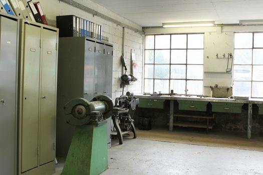 old work space with dirty dusty windows and tools with lights showing through window